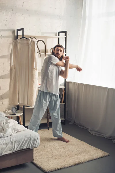 Jesús confiado en corona de espinas haciendo entrenamiento matutino en el dormitorio en casa - foto de stock