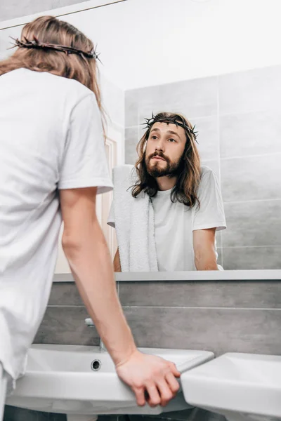 Rückansicht des Jesus mit Handtuch über der Schulter beim Betrachten des eigenen Spiegels im Badezimmer — Stockfoto