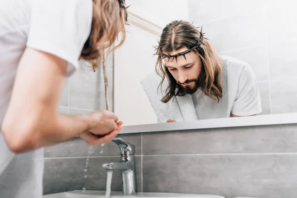 Partial view of Jesus with towel over shoulder washing hands in bathroom — Stock Photo