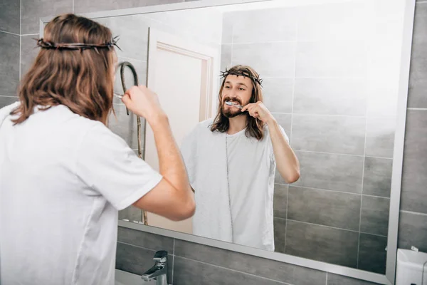 Rear view of Jesus with towel over shoulder brushing teeth in bathroom — Stock Photo