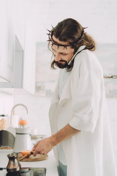 Selective focus of Jesus talking on smartphone and making coffee with cezve in kitchen during morning time at home — Stock Photo