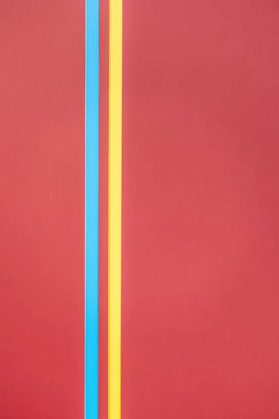 Líneas amarillas y azules sobre fondo minimalista rojo — Stock Photo