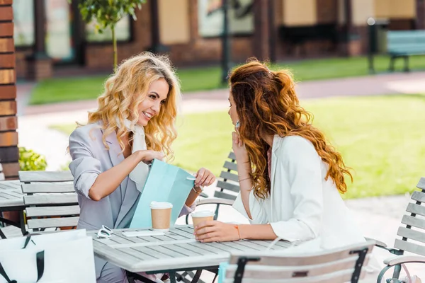 Le giovani donne alla moda controllano compra mentre si siedono in caffè dopo lo shopping — Foto stock