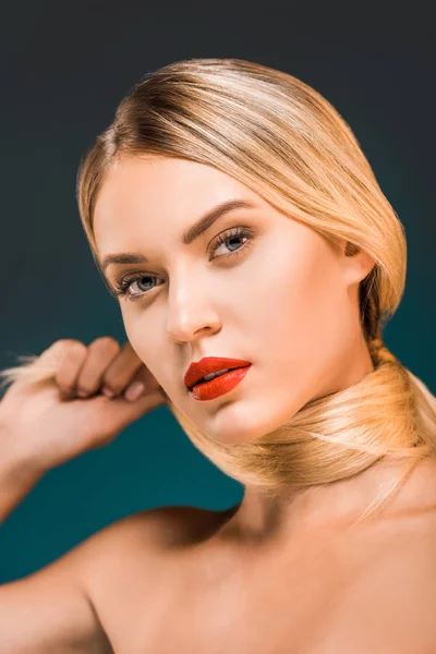 Portrait of attractive woman with red lips looking at camera on dark backdrop — Stock Photo