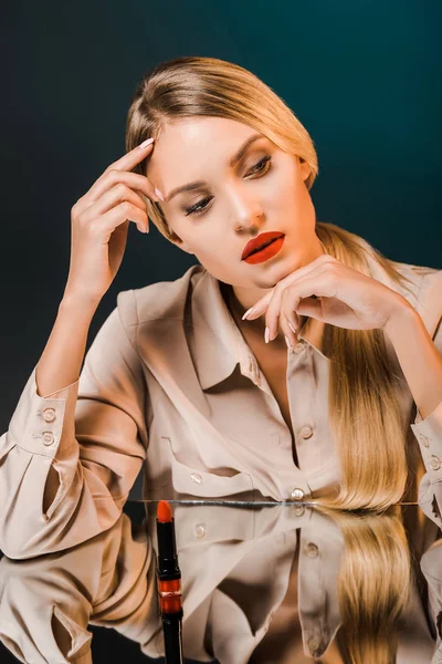 Retrato de mulher pensativa elegante e batom vermelho na superfície reflectora no fundo escuro — Fotografia de Stock