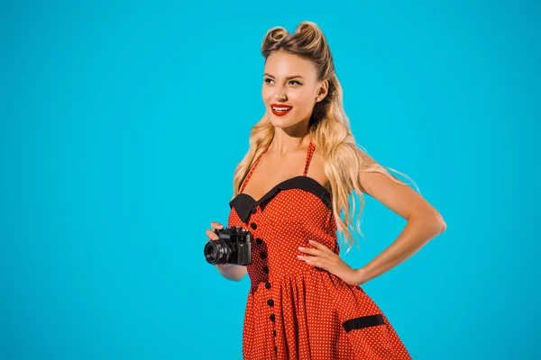 Retrato de hermosa mujer sonriente en vestido retro con cámara de fotos aislada en azul - foto de stock