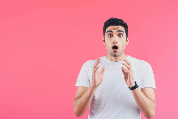 Choqué beau homme gesticulant et regardant la caméra isolée sur rose — Photo de stock