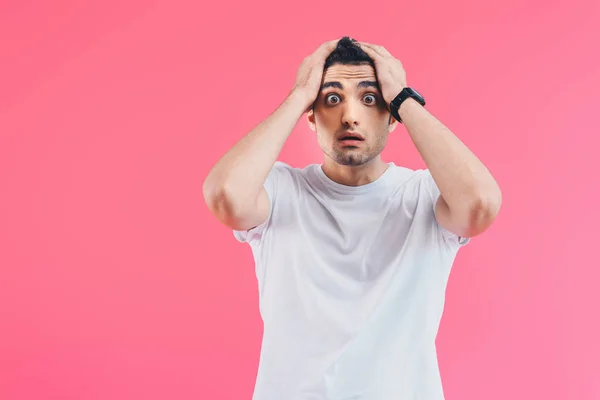 Scioccato bello uomo toccare la testa e guardando la fotocamera isolata su rosa — Foto stock