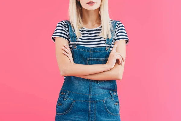 Imagem cortada de menina em jeans em pé geral com braços cruzados isolados em rosa — Fotografia de Stock