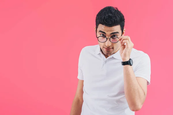 Schöner Mann blickt über Brille in Kamera isoliert auf rosa — Stockfoto