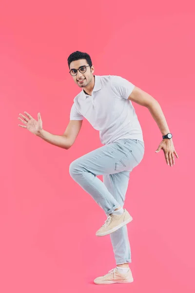 Sorrindo bonito homem fingindo correr isolado em rosa — Fotografia de Stock