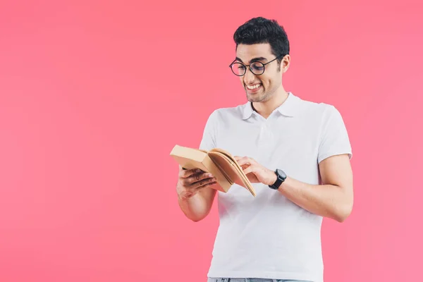Mueca sonriente estudiante lectura libro aislado en rosa - foto de stock