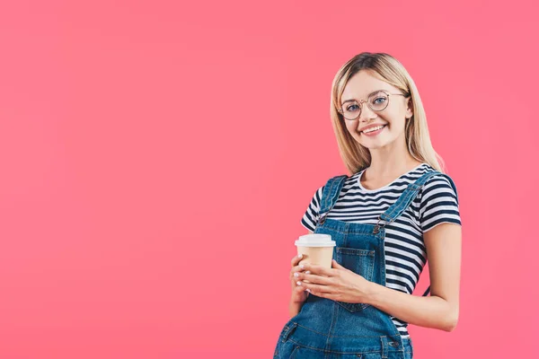 Retrato de la joven sonriente con café para ir aislado en rosa - foto de stock