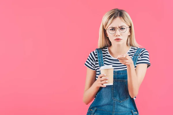 Porträt einer emotionalen Frau mit Coffee to go, die isoliert auf rosa Kamera zeigt — Stockfoto