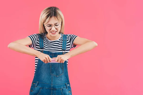 Retrato de la mujer aplastamiento smartphone aislado en rosa - foto de stock