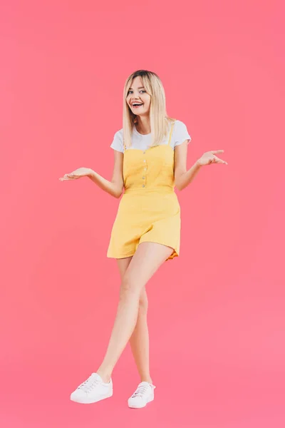 Happy young stylish woman doing dubium gesture isolated on pink — Stock Photo