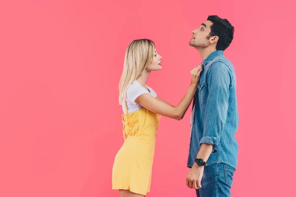 Side view of beautiful woman fastening boyfriends shirt isolated on pink — Stock Photo