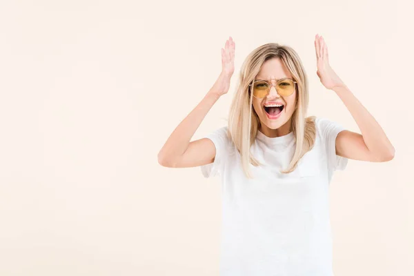 Arrabbiato giovane donna urlando e guardando la fotocamera isolata su beige — Foto stock