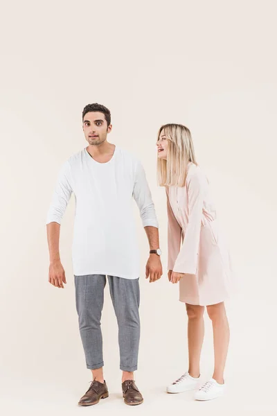 Full length view of emotional young couple standing together isolated on beige — Stock Photo