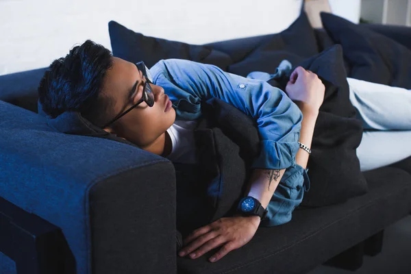 Young asian man in eyeglasses sleeping on couch at home — Stock Photo