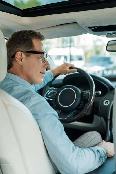 Вид ззаду красивий дорослий чоловік керує розкішним автомобілем — стокове фото