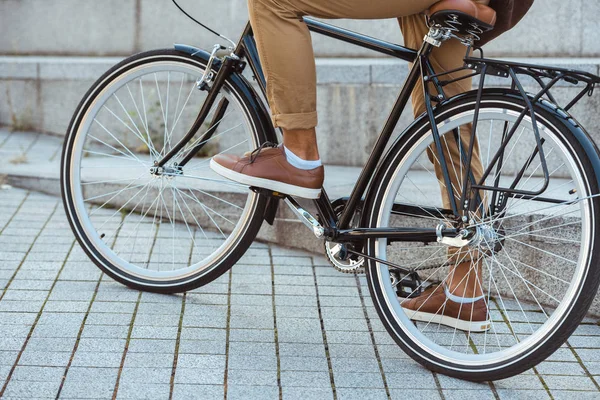 Обрезанный снимок человека, катающегося на велосипеде по улице — стоковое фото