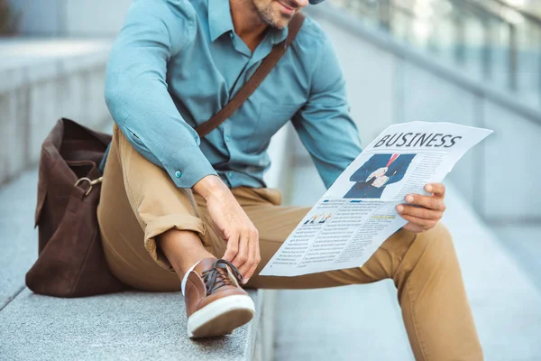 Tiro cortado de homem sentado em escadas e lendo jornal de negócios — Fotografia de Stock