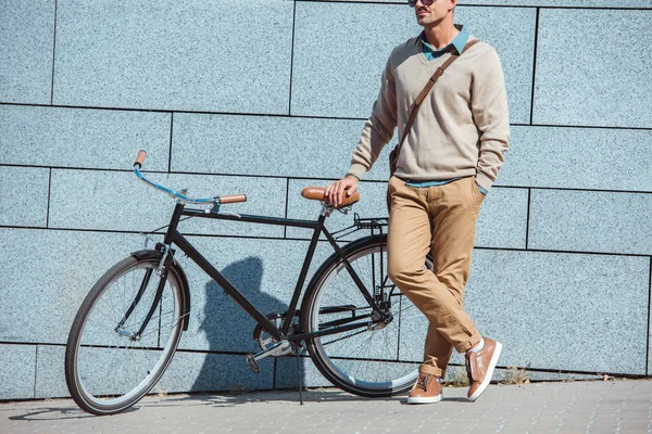 Tiro cortado de homem de meia idade elegante de pé com bicicleta na rua — Fotografia de Stock