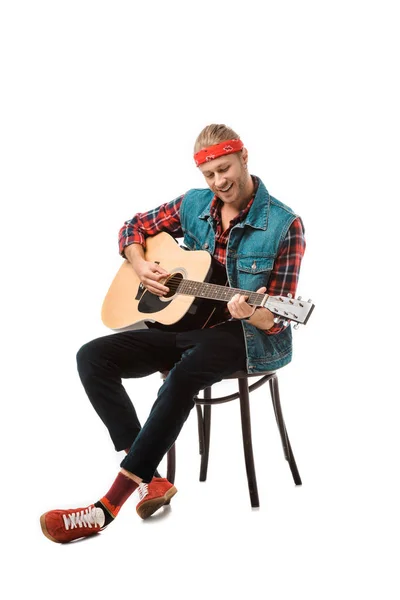 Hombre hipster feliz en chaleco vaquero tocando en la guitarra acústica aislado en blanco - foto de stock