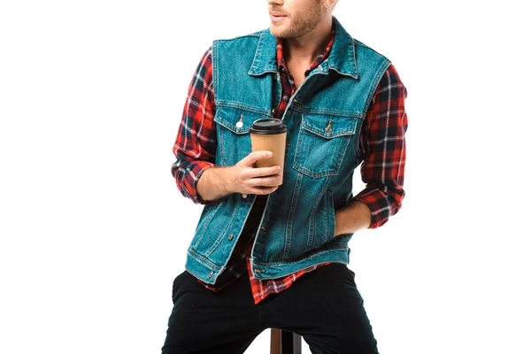 Partial view of hipster denim vest sitting on chair with coffee cup isolated on white — Stock Photo