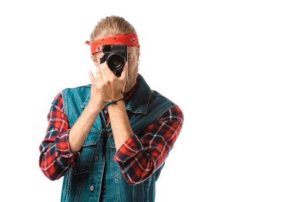 Concentrado hipster fotógrafo masculino em colete jeans e xadrez camisa tiro na câmera isolada no branco — Fotografia de Stock