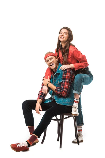 Laughing stylish man sitting on chair while his hipster girl standing behind isolated on white — Stock Photo