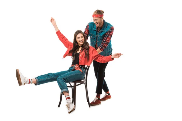 Hipster girl with wide arms sitting on chair while her happy boyfriend standing behind isolated on white — Stock Photo