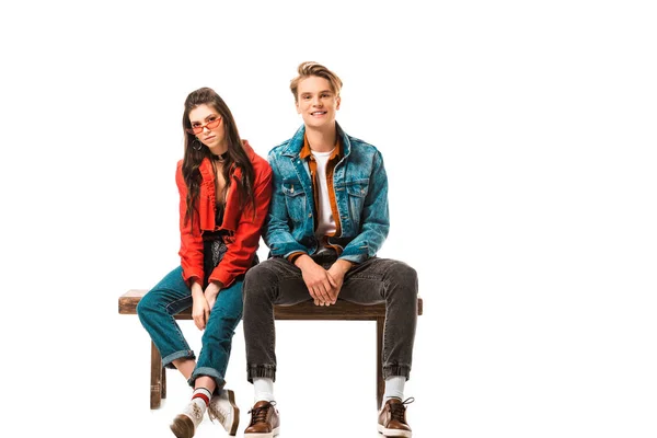 Attractive hipster girl in eyeglasses and her boyfriend sitting on bench isolated on white — Stock Photo