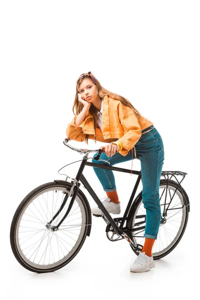 Tired hipster girl sitting on bicycle isolated on white — Stock Photo