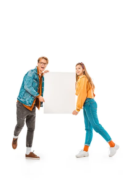 Animado elegante casal hipster segurando banner vazio isolado no branco — Fotografia de Stock