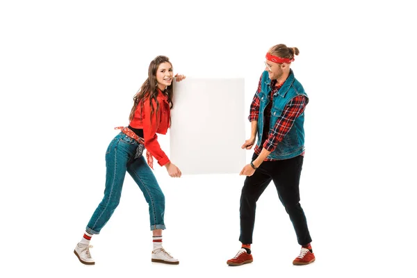 Happy stylish hipster couple holding empty banner isolated on white — Stock Photo