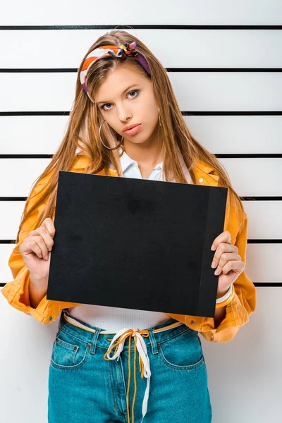 Arrestado chica elegante posando con tablero de prisión vacío en frente de la línea de policía - foto de stock