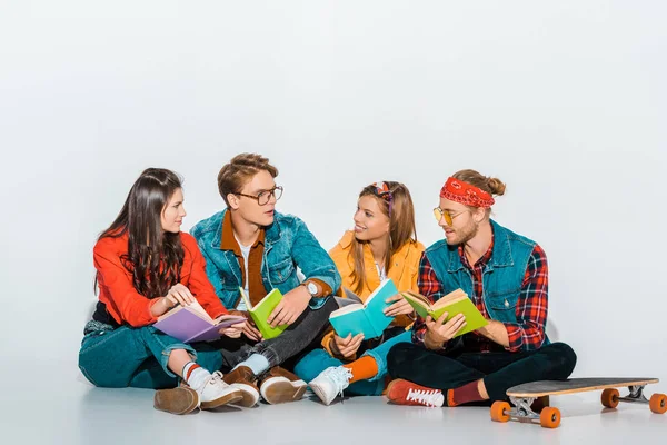 Jeunes étudiants avec des livres de longboard et parler ensemble — Photo de stock