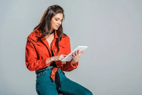 Beautiful girl using digital tablet isolated on grey — Stock Photo