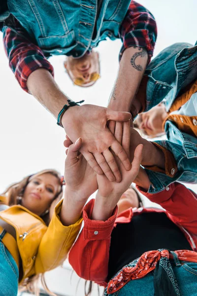 Blick von unten auf das Studententeam, das die Hände zusammenhält — Stockfoto