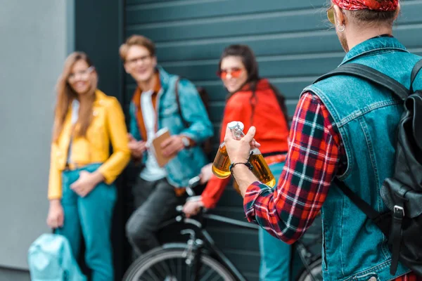 Stylish hipster brought beer for young friends on street with bike — Stock Photo