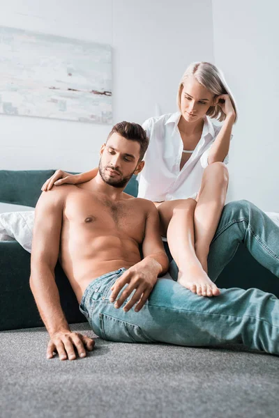 Thoughtful young couple in sitting in bedroom together — Stock Photo