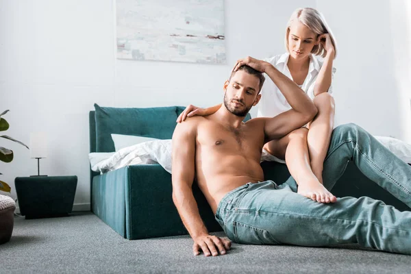 Attractive young couple in sitting in bedroom together — Stock Photo