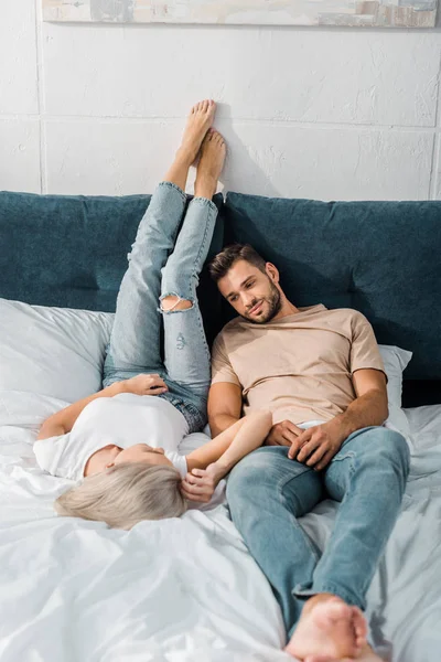 Atractiva pareja joven relajarse juntos en el dormitorio - foto de stock