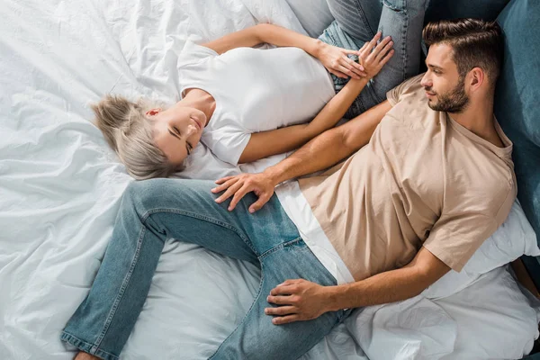 Overhead view of beautiful young couple relaxing together in bedroom — Stock Photo