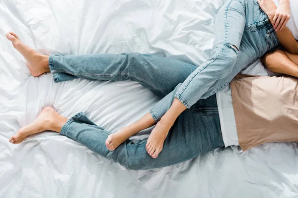 Imagen recortada de pareja joven acostada en la cama en el dormitorio - foto de stock
