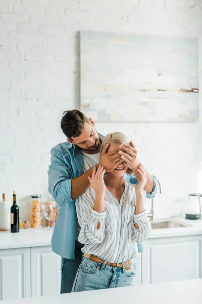 Bello fidanzato chiusura fidanzata occhi in cucina — Foto stock