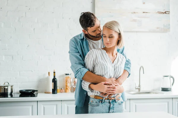 Namorado sensual abraçando namorada de volta na cozinha — Fotografia de Stock