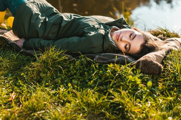 Selektiver Fokus der jungen Frau, die auf einer Decke im Freien schläft — Stockfoto